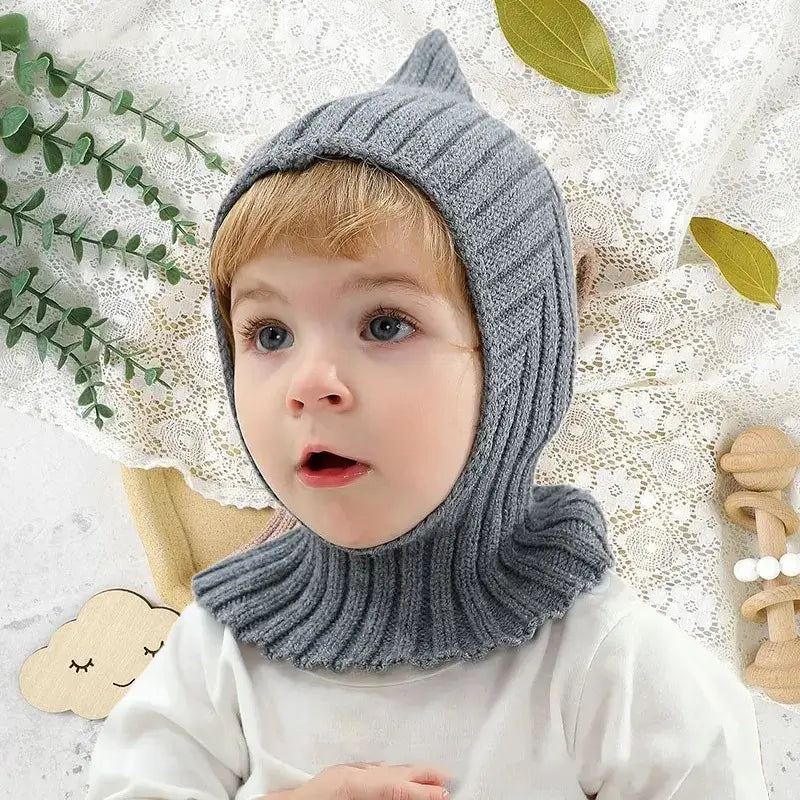 Bebeluş care poartă un cagoule din tricot moale kaki, cu un finisaj potrivit pentru o protecţie optimă împotriva cagoule pentru copii.
<p></p>
<p><img decoding=